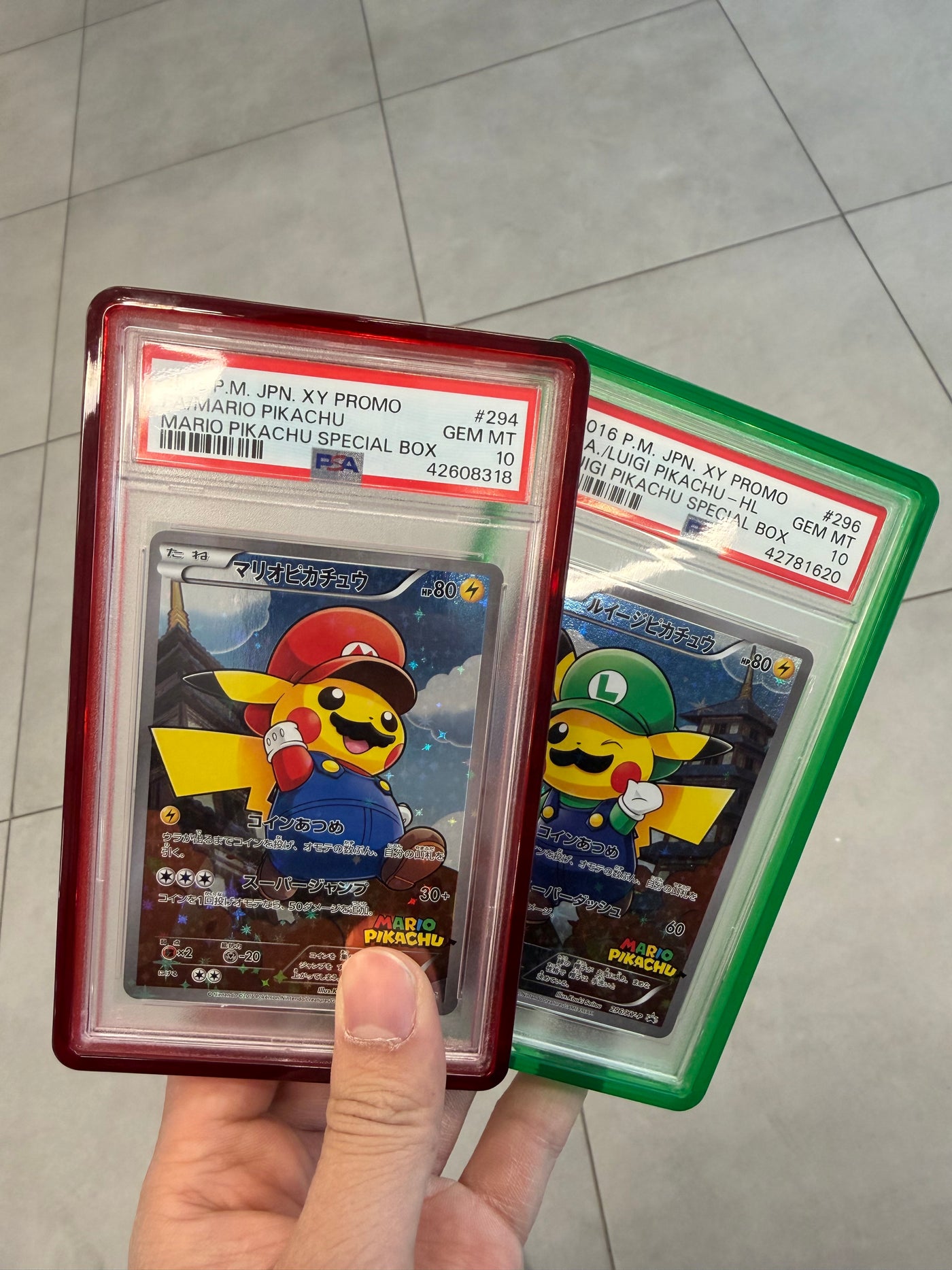 Mario and Luigi Pikachu PSA 10s in hand